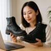 ホワイツブーツを手に取り履き心地を確かめる日本人女性が明るい部屋でブーツを眺めている様子